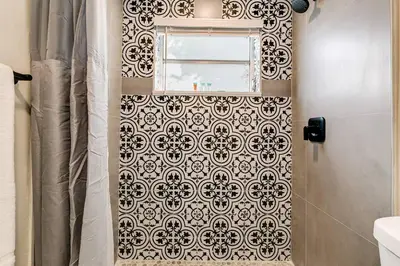 a bathroom with a shower with a black and white tile wall at Spacious 2 BR near Miami Airport Virg 5 in Miami