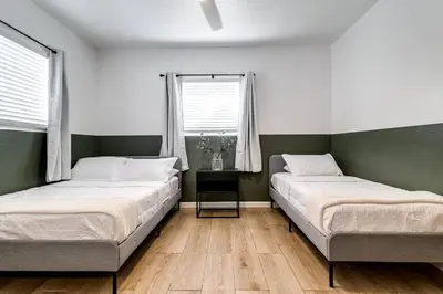 two beds in a room with two windows at Miami Airport 2-bedroom unit with speedy Wi-Fi Virg8 in Miami
