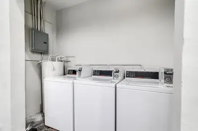 two washing machines and a tv in a room at Stylish 2BR central Fast Wi fi virg2 in Miami