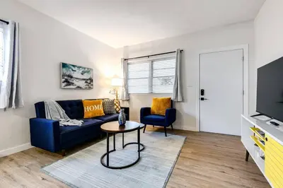 a living room with a blue couch and a table at Stylish 2BR central Fast Wi fi virg2 in Miami