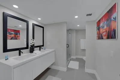 a white bathroom with two sinks and a mirror at Star Dust! Heart of Miami Dream Stay! 4 BR in Miami