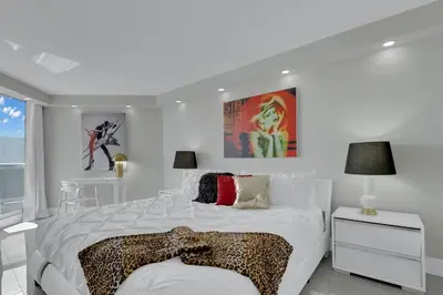 a white bedroom with a bed with a cheetah blanket at Star Dust! Heart of Miami Dream Stay! 4 BR in Miami