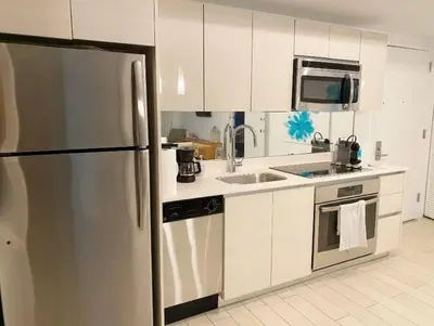a kitchen with a stainless steel refrigerator and a sink at Beach Retreat, Sleek Design & Full Kitchen -A in Hallandale Beach