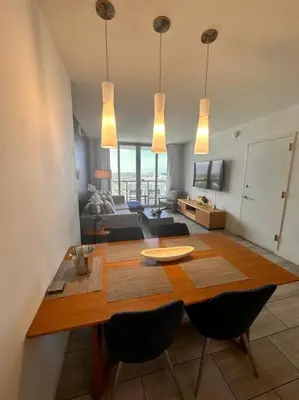 a living room with a table and chairs and a couch at High-End Miami Condo, Ocean Views & Kitchen -A in Hallandale Beach