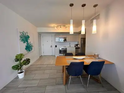 a dining room and kitchen with a table and chairs at High-End Miami Condo, Ocean Views & Kitchen -A in Hallandale Beach