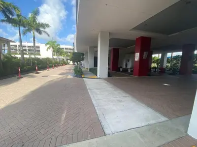 an empty street next to a building with palm trees at Luxury Beach Apartment Designer Touches & Sea Views -A in Hallandale Beach