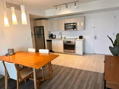 a kitchen with a wooden table and a dining room at Stylish Miami Beach Getaway Ocean Views & Kitchen -A in Hallandale Beach