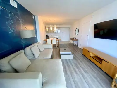 a living room with a couch and a tv at Stylish Miami Beach Getaway Ocean Views & Kitchen -A in Hallandale Beach