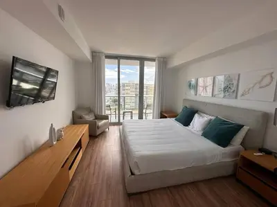 a bedroom with a large bed and a large window at Chic Miami Beach Stay, Comfort, Style & Sea Views -A in Hallandale Beach