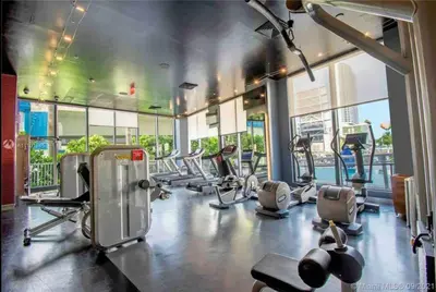 a gym with several treadmills and elliptical machines at Feel the Miami Vibe , Cozy & Stylish Studio Stay in Hallandale Beach