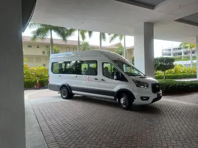 a small white van parked under a building at Disfruta como en Miami, hermoso estudio para 4 in BeachWalk in Hallandale Beach