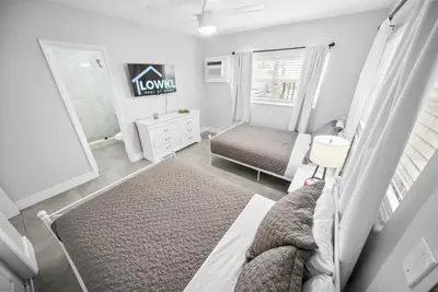 a small bedroom with a bed and a mirror at Holiday Park Apartments by Lowkl in Fort Lauderdale