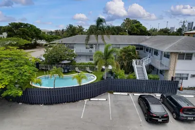 a house with a swimming pool in a parking lot at Holiday Park Apartments by Lowkl in Fort Lauderdale
