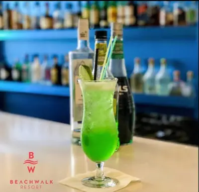 a green drink in a glass sitting on a table at Modern Miami Studio with 2 full beds, Cozy & Convenient in Hallandale Beach