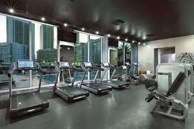 a gym with several treadmills and elliptical machines at Oceanfront Studio with Beach, Pool & Restaurants in Hallandale Beach