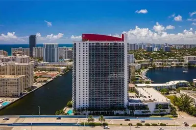 a tall building with a red roof on top of it at Oceanfront Studio with Beach, Pool & Restaurants in Hallandale Beach