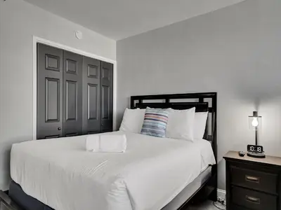 a bedroom with a white bed and a black door at Cozy Beachfront 2 BDR Miami Beach Condo 406 in Miami Beach