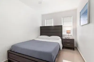 a bedroom with a large bed and a nightstand with a bed sidx sidx sidx at Lakeside Retreat with Private Yard & Kayak in Fort Lauderdale