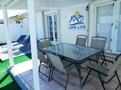 a patio with a glass table and chairs at Lakeside Retreat with Private Yard & Kayak in Fort Lauderdale
