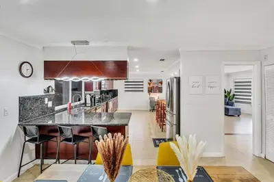 a kitchen with a counter and a kitchen island with stools at Vacation Villa W Heated Pool Beach & Casino in Hollywood