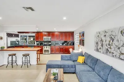a living room with a blue couch and a kitchen at Vacation Villa W Heated Pool Beach & Casino in Hollywood