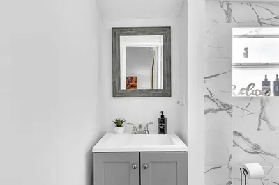 a white bathroom with a sink and a mirror at Boutique Vacation Studio - Beach, Mall, Casino Hn2 in Hallandale Beach