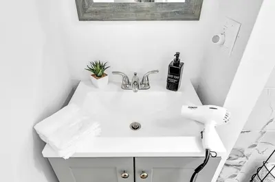 a white bathroom with a sink and a mirror at Boutique Vacation Studio - Beach, Mall, Casino Hn2 in Hallandale Beach