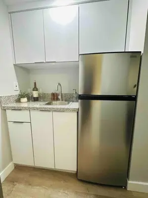 a kitchen with a stainless steel refrigerator and white cabinets at Coral Gables Miami Studio near Airport and Beaches in Miami