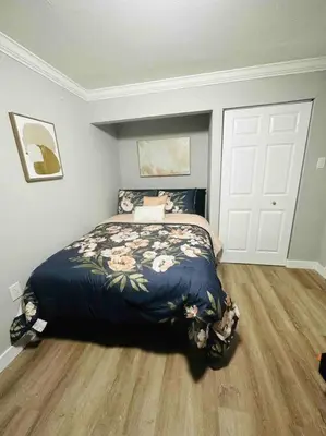 a bedroom with a bed with a blue comforter at Coral Gables Miami Studio near Airport and Beaches in Miami