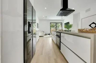 a kitchen with white walls and black appliances at Radiance - Modern Design, Poolside Escape in Miami