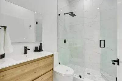 a white bathroom with a shower and a toilet at Radiance - Modern Design, Poolside Escape in Miami