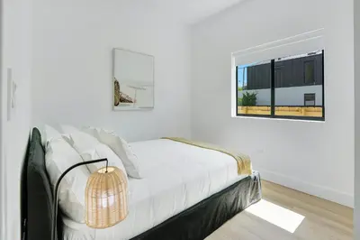 a white bedroom with a bed and a window at Radiance - Modern Design, Poolside Escape in Miami