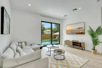 a white living room with a couch and a table at Radiance - Modern Design, Poolside Escape in Miami