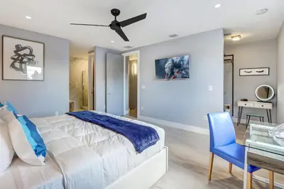 a bedroom with a large bed and a blue chair at Deco Delight - Central Hub in Miami