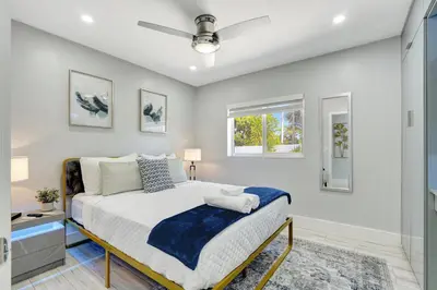a bedroom with a bed and a window at The Gardens - Luxe, Pool, Mins to Hard Rock Stadium in Miami Gardens