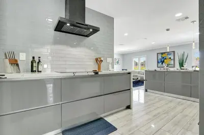 a kitchen with stainless steel cabinets and a stove at The Gardens - Luxe, Pool, Mins to Hard Rock Stadium in Miami Gardens
