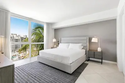 a bedroom with a bed and a large window at Tiffany Hazel - Rooftop Pool, Gym, & Walk to Beach in Fort Lauderdale