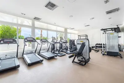 a gym with a bunch of treadmills and ellipticals at Tiffany Hazel - Rooftop Pool, Gym, & Walk to Beach in Fort Lauderdale
