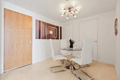 a dining room with a table and white chairs at Tiffany Sage - Rooftop Pool, Gym, & Walk to Beach in Fort Lauderdale