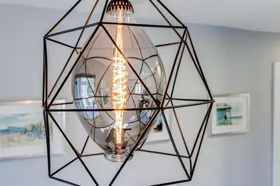 a glass orb chandelier hanging from a ceiling at Renovated professional design, grill lake view! in Hallandale Beach
