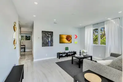 a living room with a couch and a table at Renovated professional design, grill lake view! in Hallandale Beach