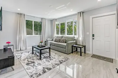 a living room with a couch and a table at Renovated professional design, grill lake view! 1 in Hallandale Beach