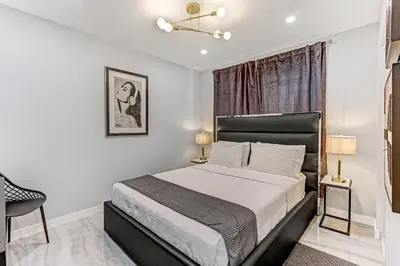 a bedroom with a bed and a chair and a window at Renovated professional design, grill lake view! 1 in Hallandale Beach