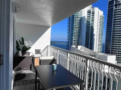 a balcony with a table and a view of a city at Luxury Brickell Waterfront View - Amazing Furnished Balcony - Walk-Water-WiFi in Miami