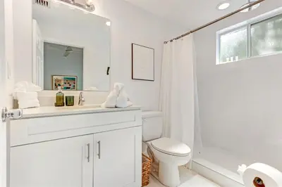 a white bathroom with a toilet and a shower at Artease 2 -Largest, stylish, Peloton bike, near Wynwood Walls & restaurants in Miami