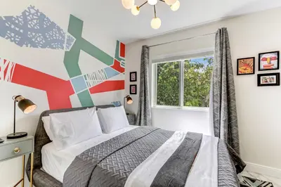a bedroom with a bed with a colorful wall at ArTease3 - stylish, near Wynwood Walls & restaurants in Miami