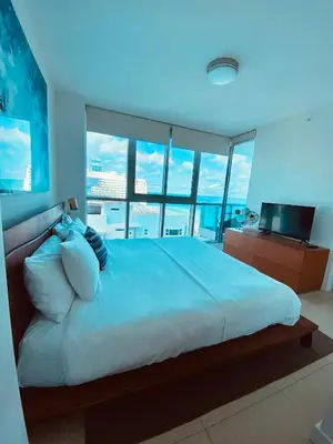 a bedroom with a large bed with a view of the ocean at Monte Carlo Suites in Miami Beach in Miami Beach