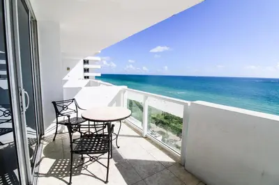 a balcony with a table and chairs and the ocean at Castle 1029 Balcony studio with Ocean View, Pool, Tennis and Free Parking in Miami Beach