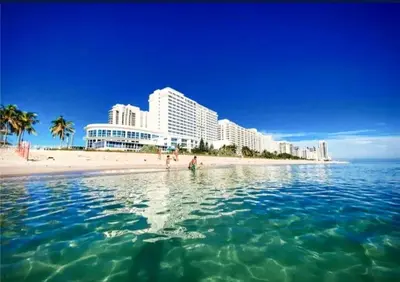 a group of people standing in the water at the beach at Castle 1029 Balcony studio with Ocean View, Pool, Tennis and Free Parking in Miami Beach