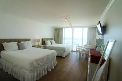 a hotel room with two beds and a television at Castle 1029 Balcony studio with Ocean View, Pool, Tennis and Free Parking in Miami Beach